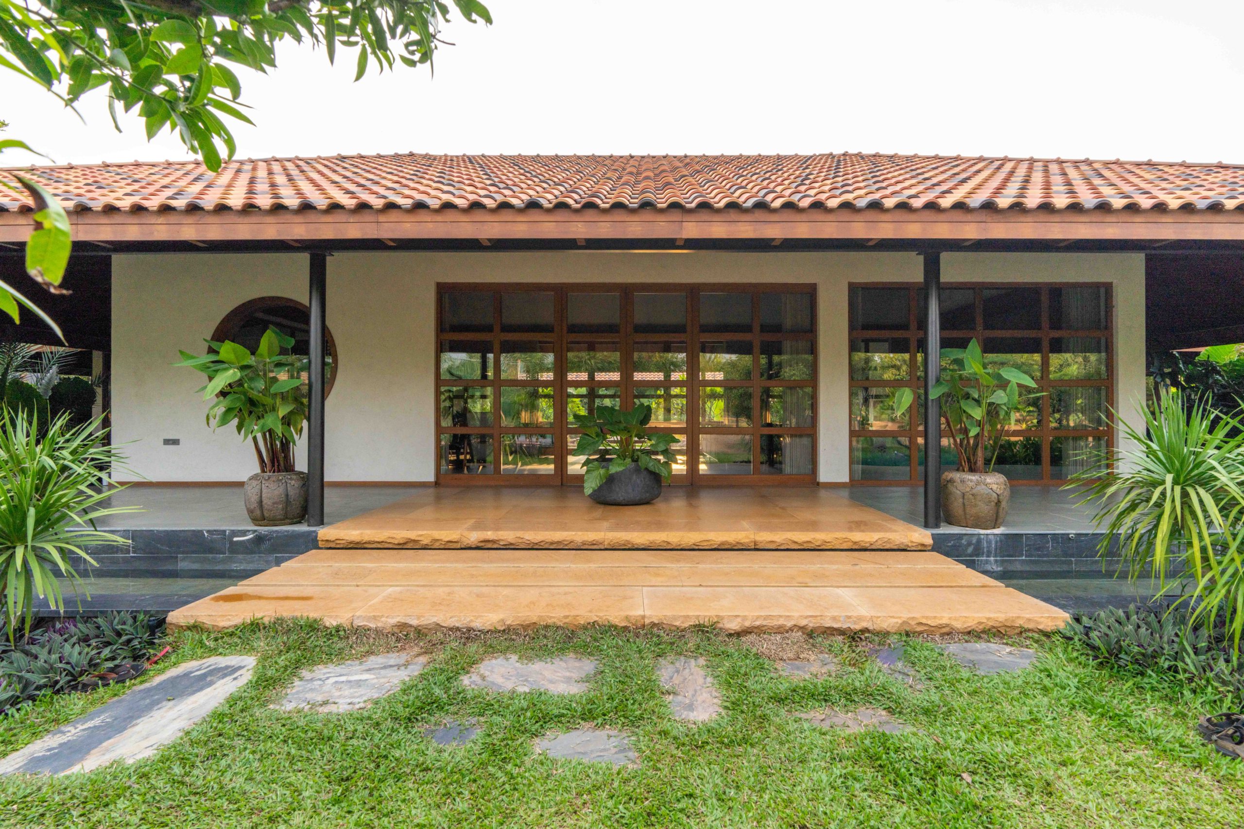 Villa entrance with large solid wood window and door